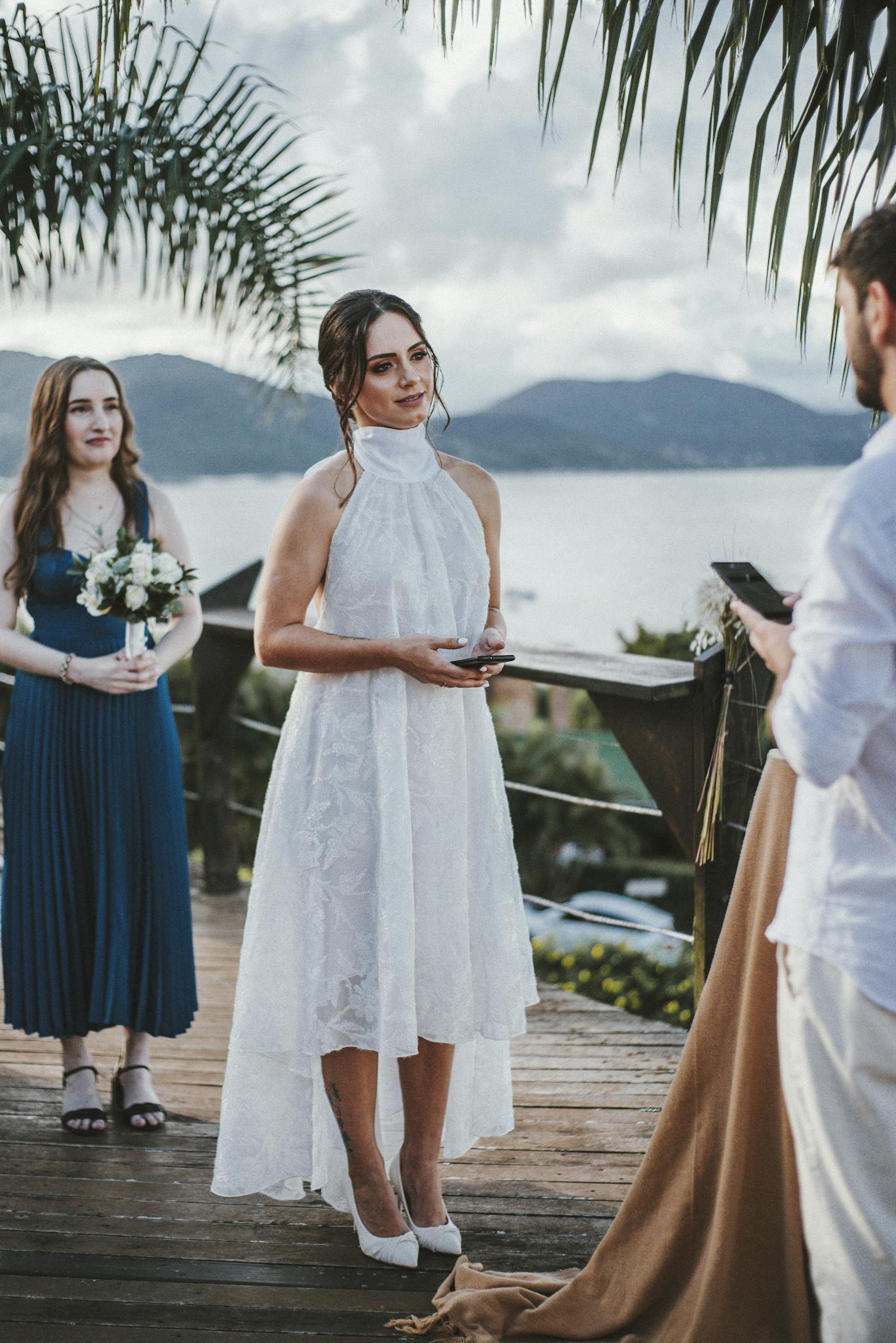 A beautiful couple exchanging vows during a tropical outdoor wedding by the sea.